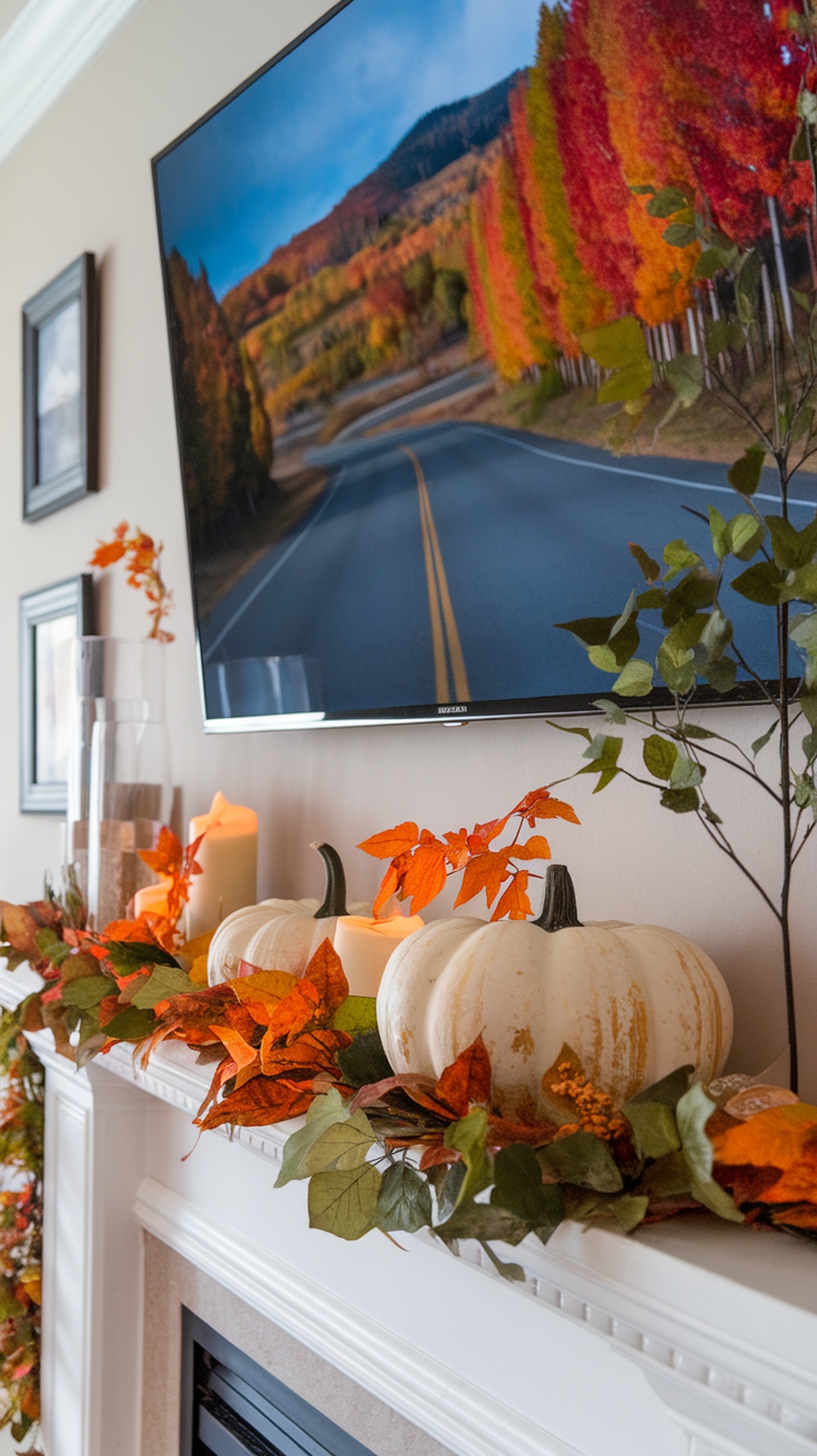 A cozy mantle decorated with pumpkins, leaves, and a TV displaying a scenic autumn landscape.